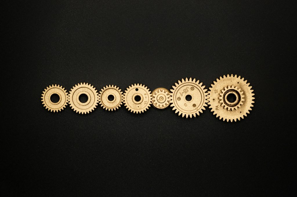 An artistic arrangement of golden gears on a dark backdrop, symbolizing mechanics and cooperation.